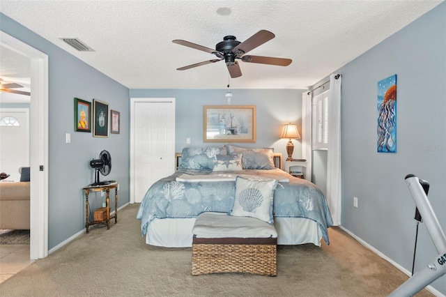 carpeted bedroom with a textured ceiling, a closet, and ceiling fan