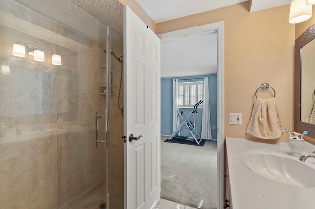 bathroom featuring vanity, a shower with shower door, and a textured ceiling