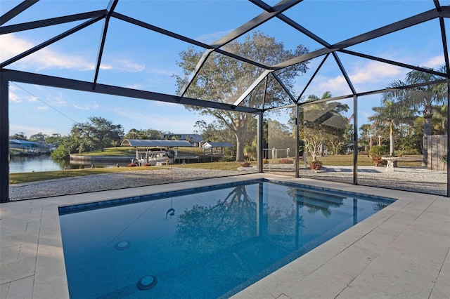 view of swimming pool with a water view, a patio area, and a lanai