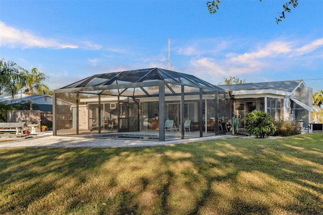 back of property with a patio area, a lanai, and a yard