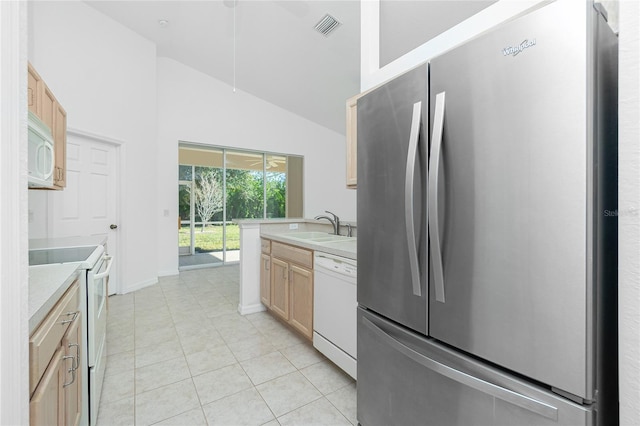 kitchen with white appliances, lofted ceiling, light brown cabinets, sink, and light tile patterned flooring