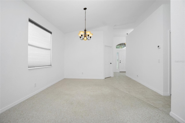 empty room featuring a chandelier, light colored carpet, and baseboards