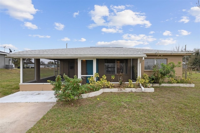 ranch-style house with a sunroom and a front lawn