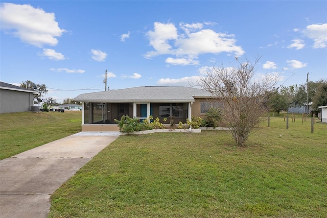 view of front of property with a sunroom and a front yard