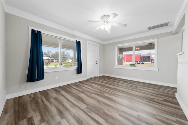 unfurnished room featuring a ceiling fan, visible vents, baseboards, and wood finished floors