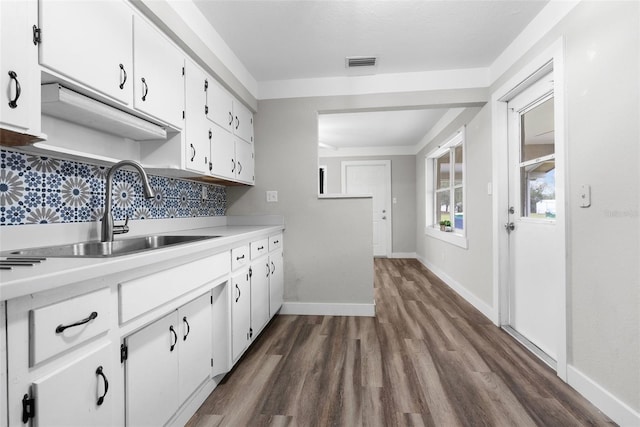 kitchen with white cabinetry, dark hardwood / wood-style floors, sink, and decorative backsplash