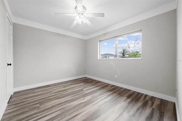 unfurnished room with a ceiling fan, baseboards, and wood finished floors