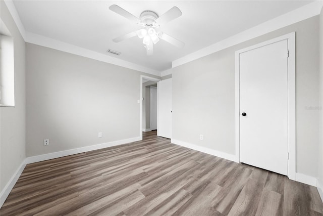 unfurnished bedroom featuring light wood finished floors, baseboards, visible vents, and ceiling fan