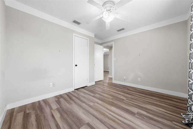 unfurnished bedroom with baseboards, visible vents, ceiling fan, and wood finished floors