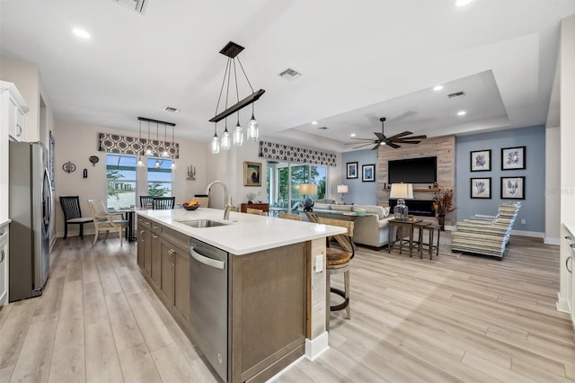 kitchen with a raised ceiling, white cabinetry, sink, and appliances with stainless steel finishes