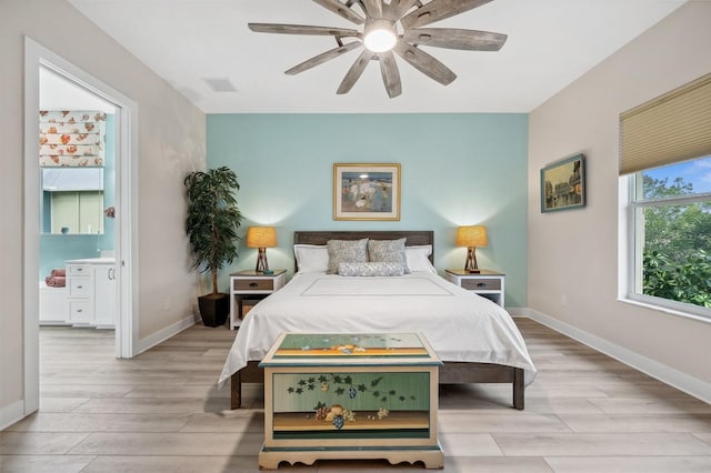 bedroom featuring ensuite bath, ceiling fan, and light wood-type flooring