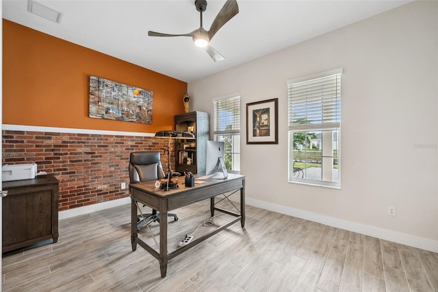 office with ceiling fan, light hardwood / wood-style flooring, and brick wall