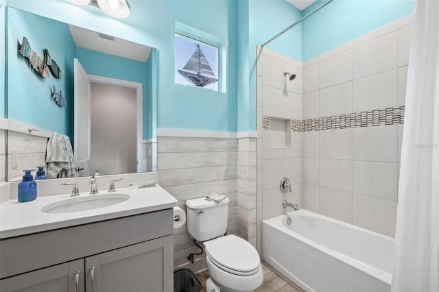 full bathroom with vanity, shower / bathtub combination with curtain, tile walls, and toilet