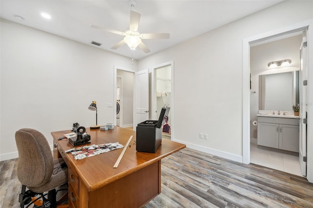 office area featuring wood-type flooring, ceiling fan, and sink