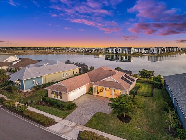 aerial view at dusk featuring a water view