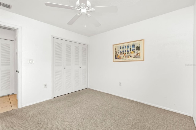 unfurnished bedroom with light carpet, a closet, and ceiling fan