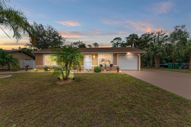 single story home featuring a yard and a garage