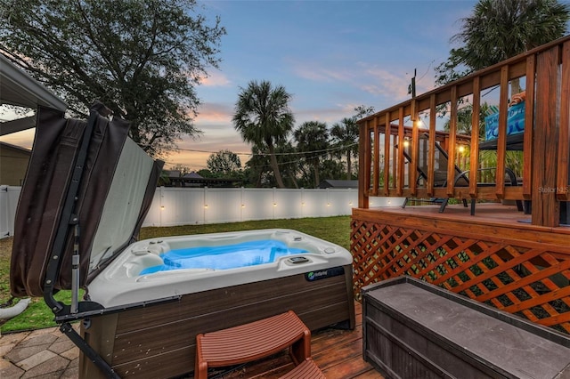 deck at dusk with a hot tub