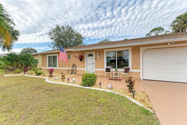 single story home featuring a front yard, a garage, and covered porch