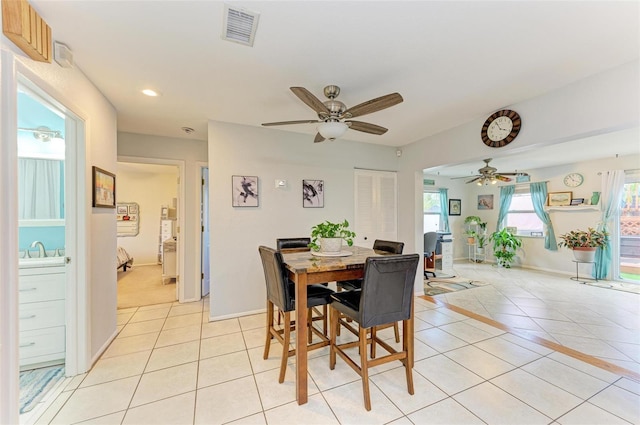 dining area with ceiling fan, sink, and light tile patterned floors