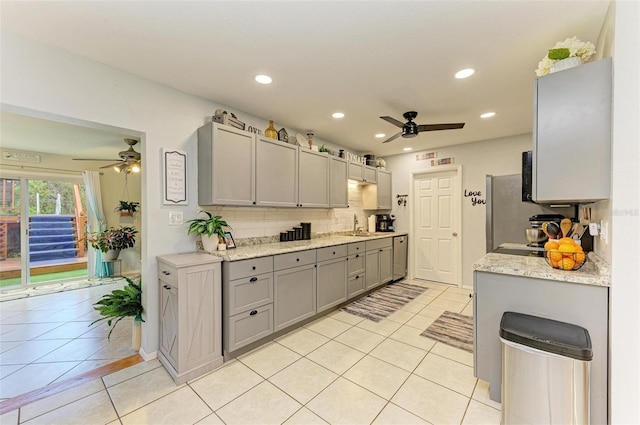 kitchen featuring light tile patterned floors, tasteful backsplash, ceiling fan, and gray cabinetry