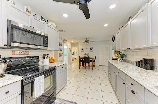 kitchen with white cabinetry, black electric range oven, ceiling fan, and light tile patterned flooring