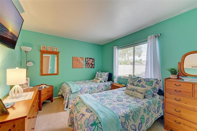 bedroom featuring light colored carpet and a textured ceiling