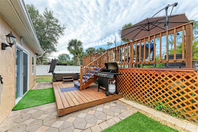 wooden deck featuring area for grilling, a patio, and a hot tub