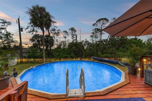 pool at dusk with a deck