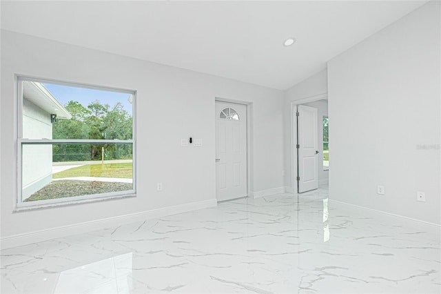 unfurnished room featuring lofted ceiling