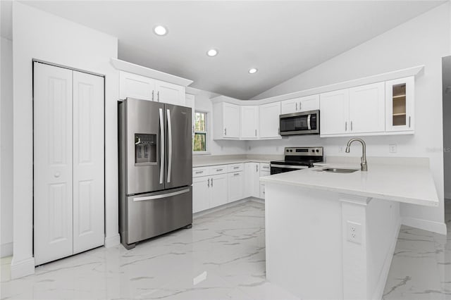 kitchen featuring white cabinets, vaulted ceiling, appliances with stainless steel finishes, and sink