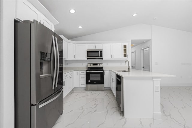 kitchen with sink, white cabinets, appliances with stainless steel finishes, and vaulted ceiling