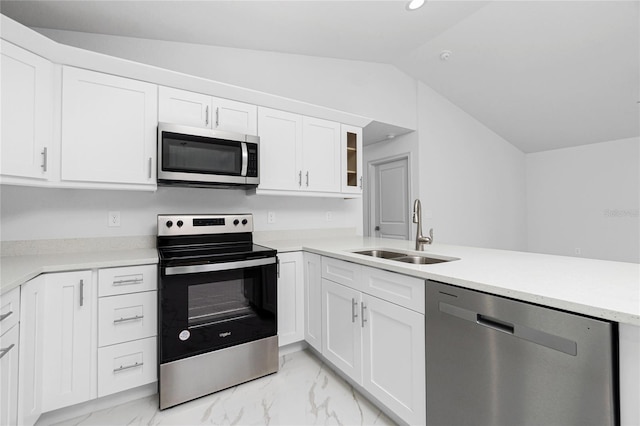 kitchen with appliances with stainless steel finishes, white cabinetry, sink, kitchen peninsula, and vaulted ceiling