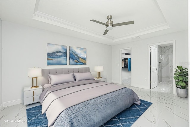 bedroom with ensuite bathroom, ceiling fan, a tray ceiling, and ornamental molding