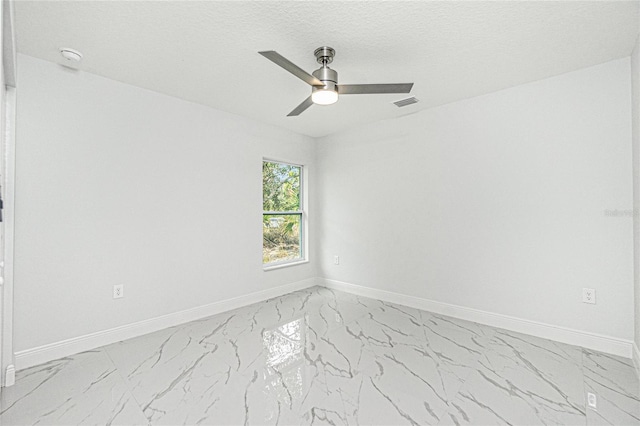 spare room featuring ceiling fan and a textured ceiling