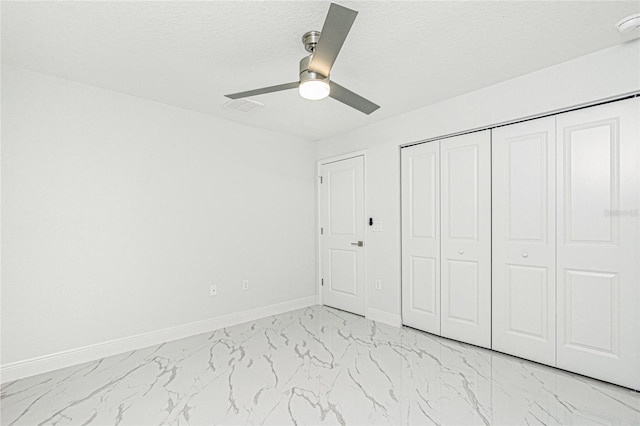 unfurnished bedroom featuring a textured ceiling, ceiling fan, and a closet