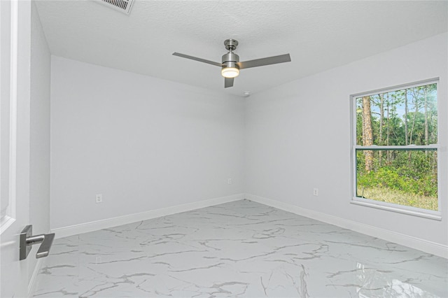 unfurnished room featuring a textured ceiling, ceiling fan, and a wealth of natural light