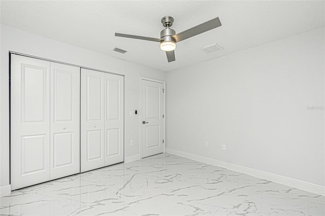 unfurnished bedroom with ceiling fan and a closet