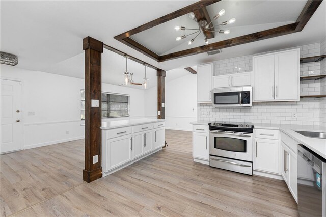 kitchen with hanging light fixtures, vaulted ceiling, appliances with stainless steel finishes, and white cabinets