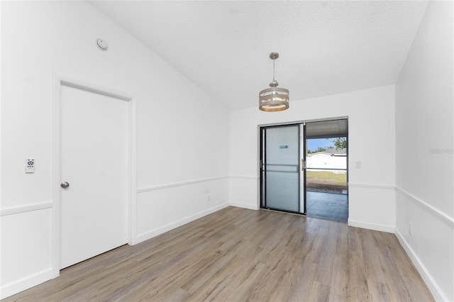 unfurnished room featuring light hardwood / wood-style flooring and a textured ceiling