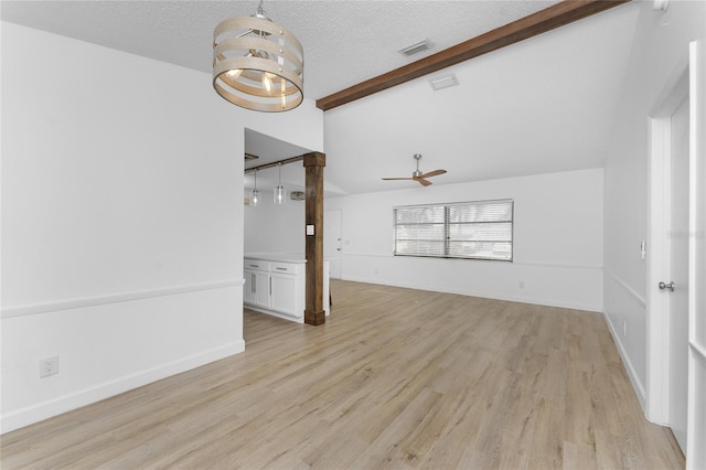 unfurnished living room with ceiling fan, light hardwood / wood-style flooring, vaulted ceiling with beams, and a textured ceiling