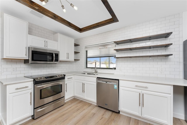 kitchen featuring sink, stainless steel appliances, light hardwood / wood-style floors, and white cabinets