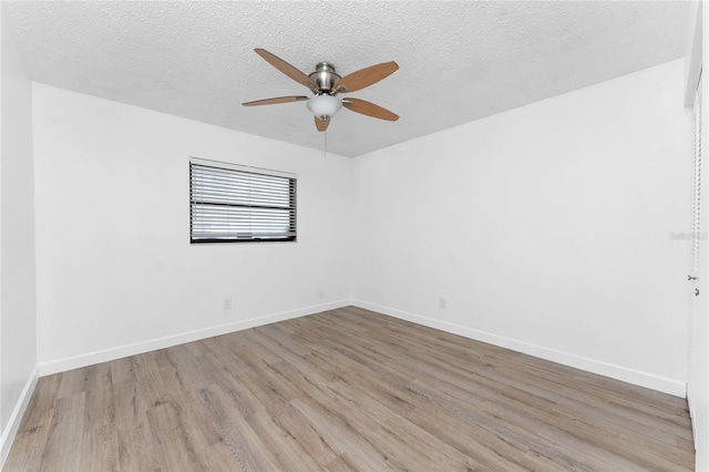 empty room with a textured ceiling, light hardwood / wood-style floors, and ceiling fan