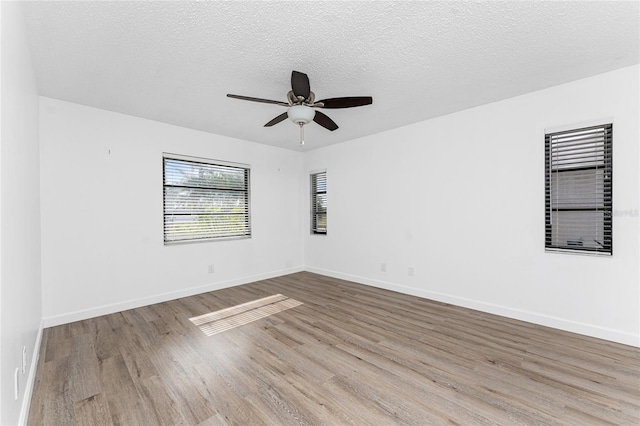 empty room with ceiling fan, a textured ceiling, and light hardwood / wood-style floors