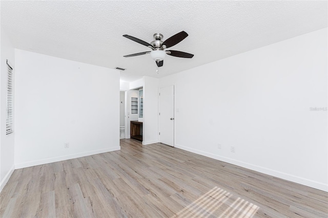 unfurnished room with ceiling fan, a textured ceiling, and light hardwood / wood-style floors