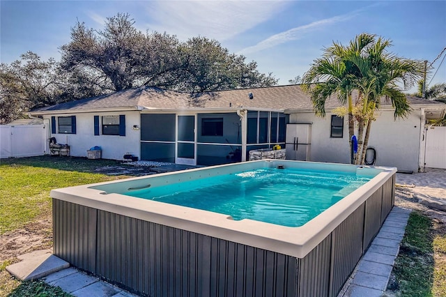 view of pool with a yard, a hot tub, and a sunroom