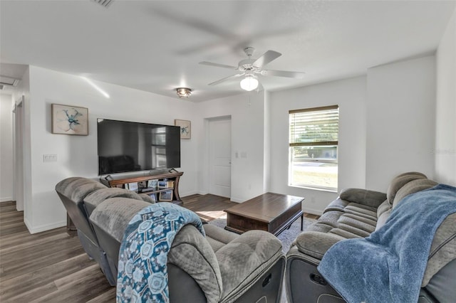 living room featuring ceiling fan and dark wood-type flooring