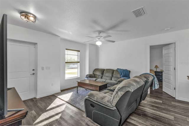 living room with ceiling fan and dark wood-type flooring