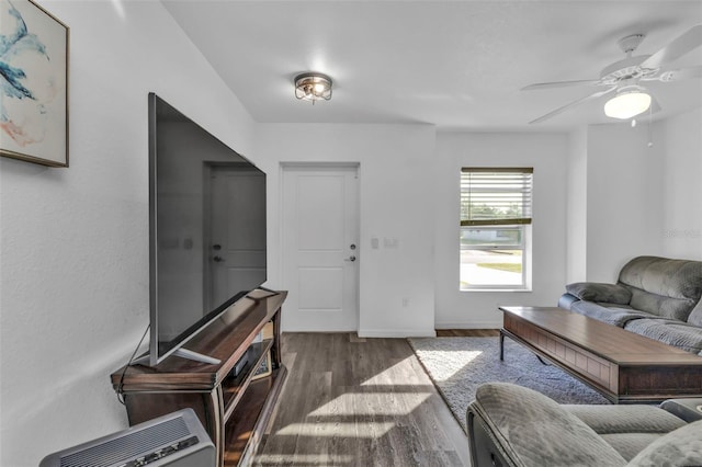 living room featuring dark hardwood / wood-style floors, heating unit, and ceiling fan