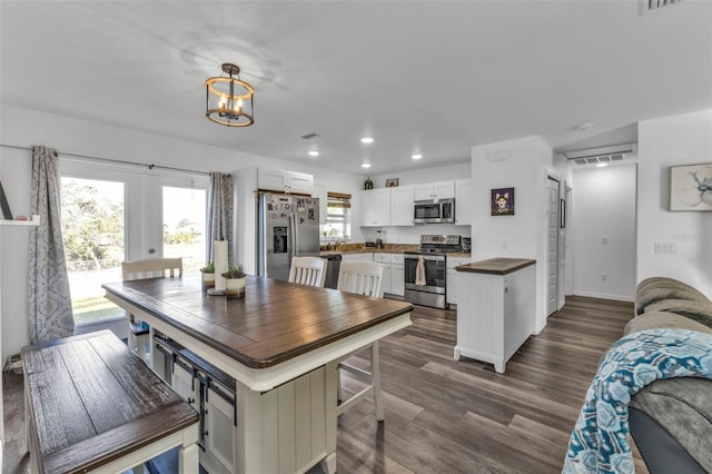 dining area featuring a chandelier, french doors, dark wood-type flooring, and sink